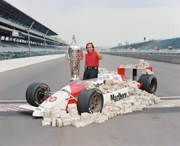 Emerson Fittipaldi posando junto a su premio Indy 500 de 1989.