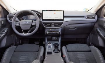 Vista delantera del habitáculo del Ford Kuga mostrando volante y sistema de infotainment.