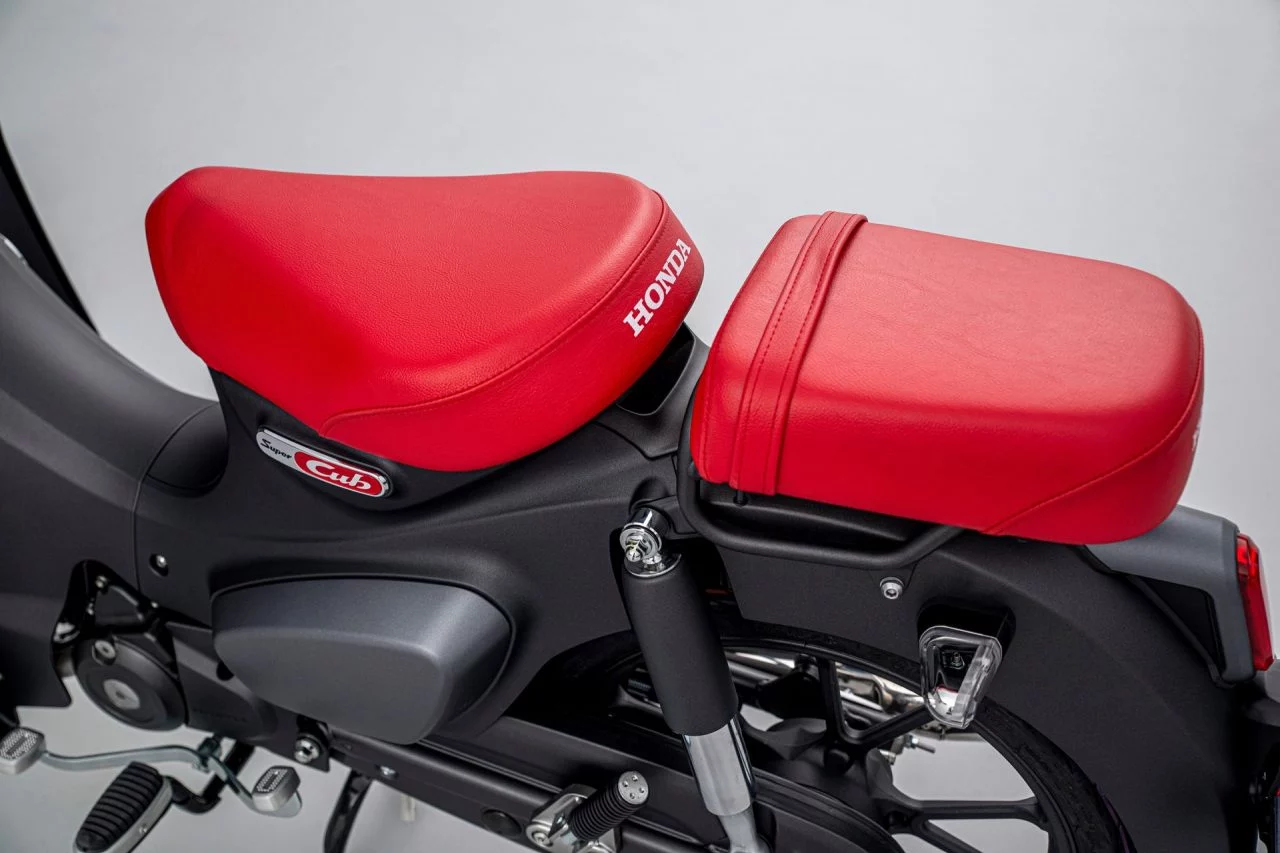 Asientos ergonómicos rojos Honda Super Cub 125, icono en movilidad urbana.