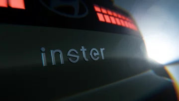 Vista parcial trasera del próximo Hyundai Inster, foco en diseño luminoso y logotipo.