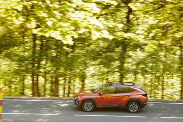 Vista lateral del Hyundai Tucson 2024 en movimiento, destacando su diseño aerodinámico.