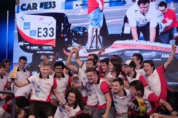 Un equipo de universitarios celebra junto a su monoplaza de competición.