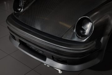 Primer plano del frontal del Porsche, mostrando la calidad y diseño aerodinámico.