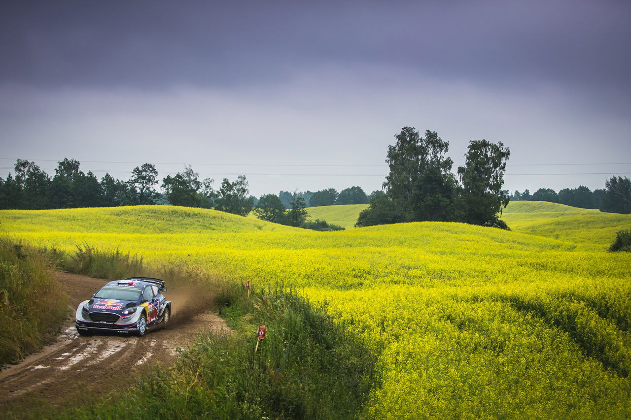 Vehículo competiendo en el Rally de Polonia 2024, mostrando habilidad sobre terreno irregular.