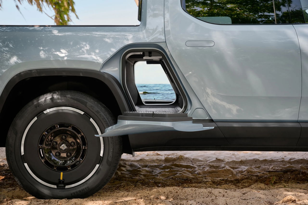 Vista lateral del Rivian R1T, mostrando su robustez y capacidad todoterreno.