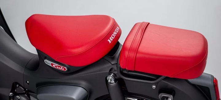 Detalle de la Honda Super Cub 125 con asiento y caja de reparto en rojo