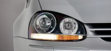 Vista cercana del faro delantero de un Volkswagen, destaca su diseño clásico.