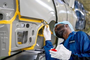 Trabajador inspeccionando la calidad de acabados en un lateral del Volvo EX90.