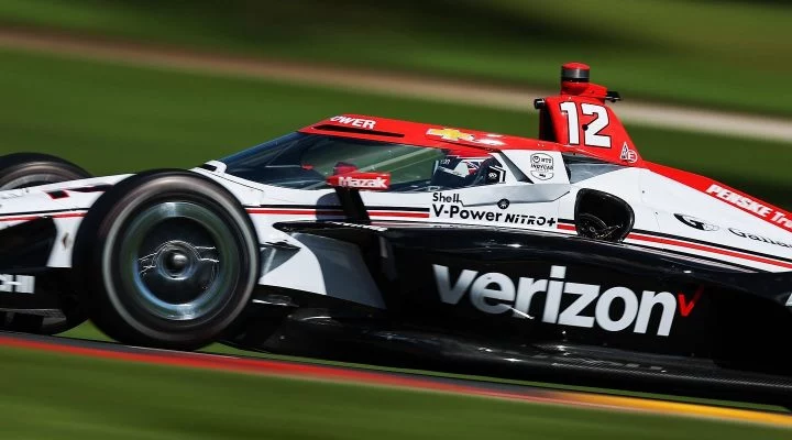 Monoplaza de IndyCar en acción en Road America, dinamismo y velocidad en pista