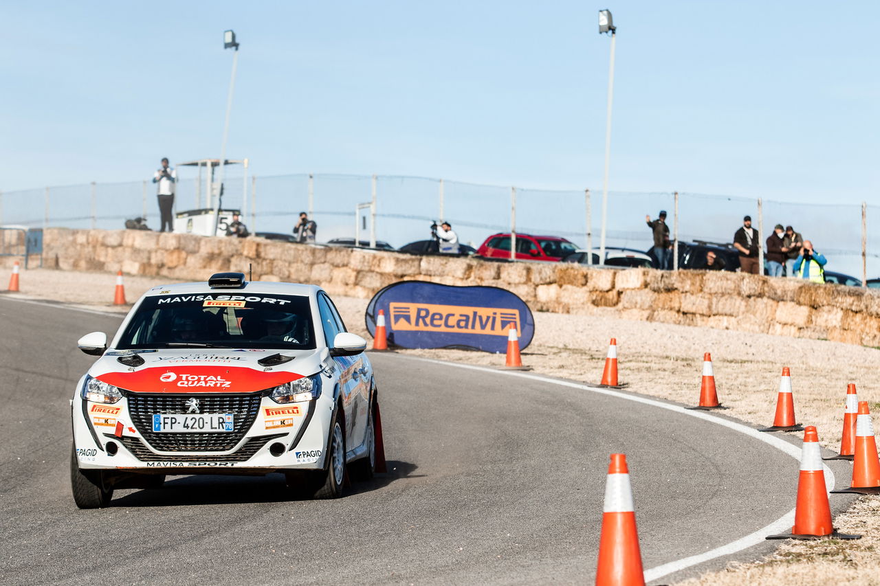 Vehículo de competición tomando curva en circuito de rally, demostrando agilidad y diseño aerodinámico.