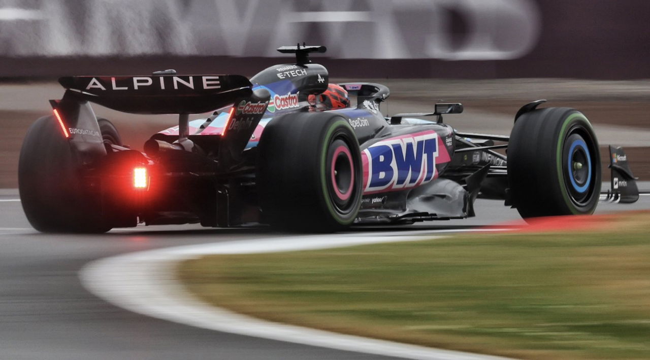 Monoplaza de Alpine F1 en acción en pista, vista trasera-lateral