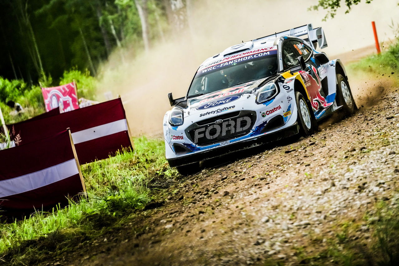 Ford competidor en Rally de Letonia atravesando a gran velocidad una sección de tierra.