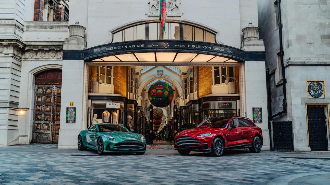 Dos Aston Martin DB5 coloreados frente a la entrada de un edificio clásico