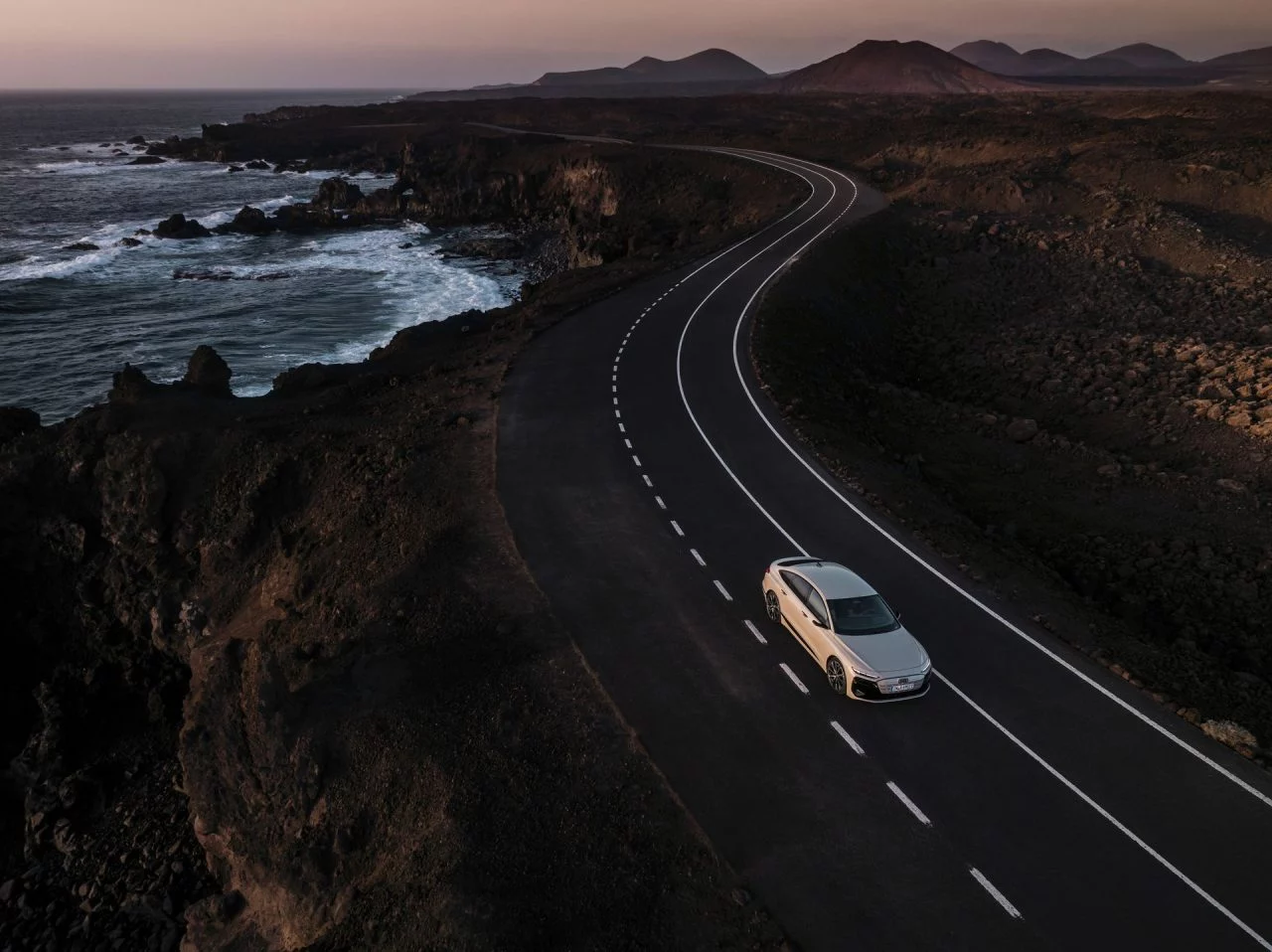 La silueta del Audi A6 e-tron destaca, elegantemente iluminada al atardecer.