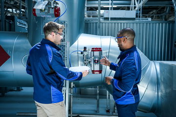 Dos ingenieros analizando equipamiento industrial BMW.