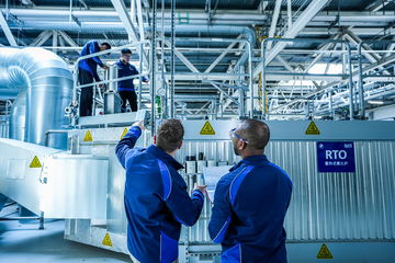 Imagen de profesionales inspeccionando maquinaria industrial, posible relación con fabricación de vehículos BMW.