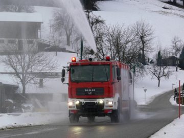 Camión con doble cabina avanzando por una carretera nevada.