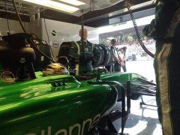 Vista lateral del Caterham CT05 en boxes, enfocado en aerodinámica.