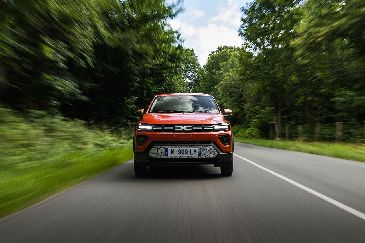 Dacia Spring en movimiento, destacando su diseño frontal y eficiencia.