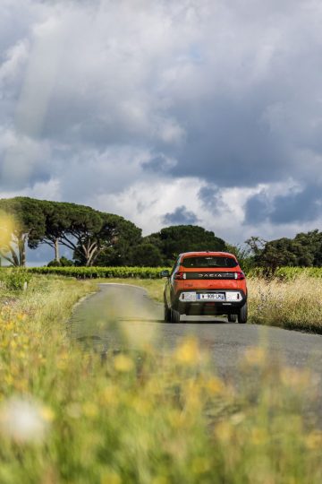 Vista trasera lateral del Dacia Spring 2024 en entorno campestre