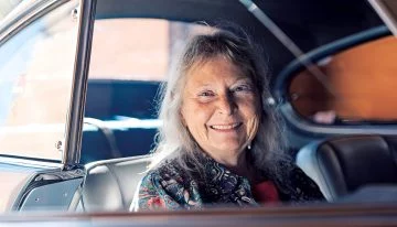 Imagen de una mujer sonriendo desde el asiento de un Ferrari 166 Inter.