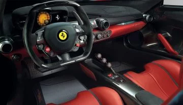 Cabina del Ferrari que integra elementos de F1, mostrando volante y asientos.