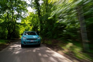 Vista dinámica del Fiat híbrido avanzando por carretera rodeada de vegetación