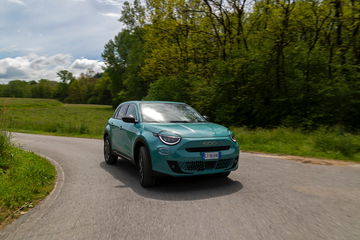 Vista dinámica del FIAT 600 Hybrid en carretera, mostrando su diseño frontal y línea lateral.