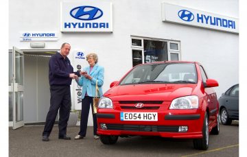 Imagen de un Hyundai rojo durante la entrega de llaves al nuevo propietario