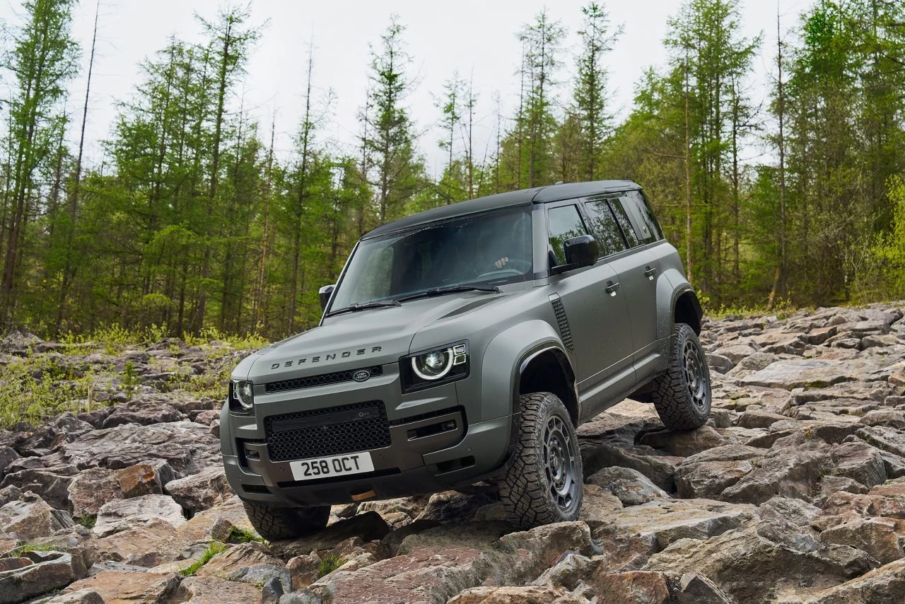 Land Rover Defender conquistando terreno pedregoso con robustez.