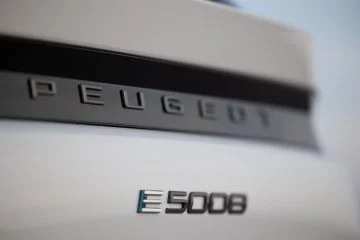 Vista cercana de la insignia que identifica el modelo electrificado Peugeot e-5008