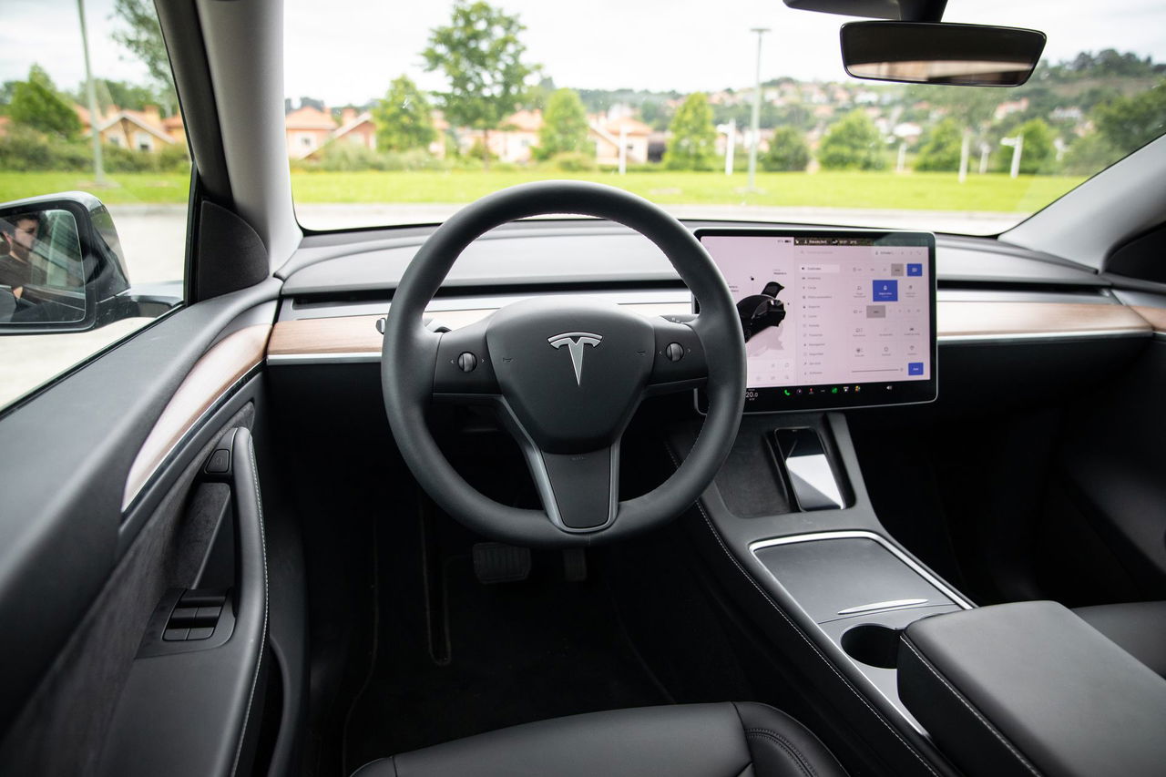 Vista lateral de la cabina del Tesla Model Y destacando su minimalismo y tecnología.