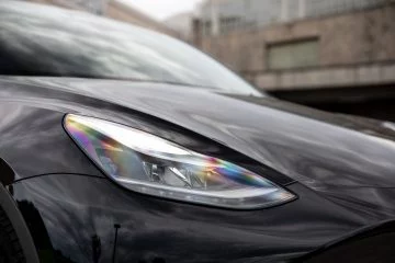 Primer plano del faro LED de un Tesla Model Y, resaltando su diseño moderno.