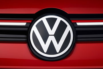 Emblema icónico del Volkswagen Golf GTI sobre parrilla roja.