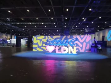 Escenario promocional en evento de tecnología y movilidad en Londres, sin vehículos visibles.