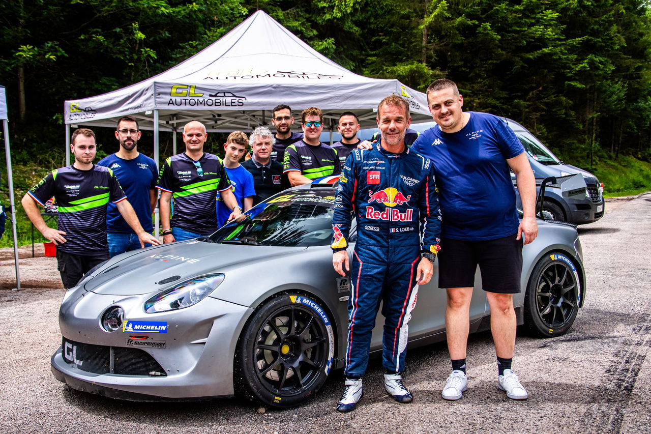 Sébastien Loeb y equipo junto al Alpine A110 RGT en evento de rally