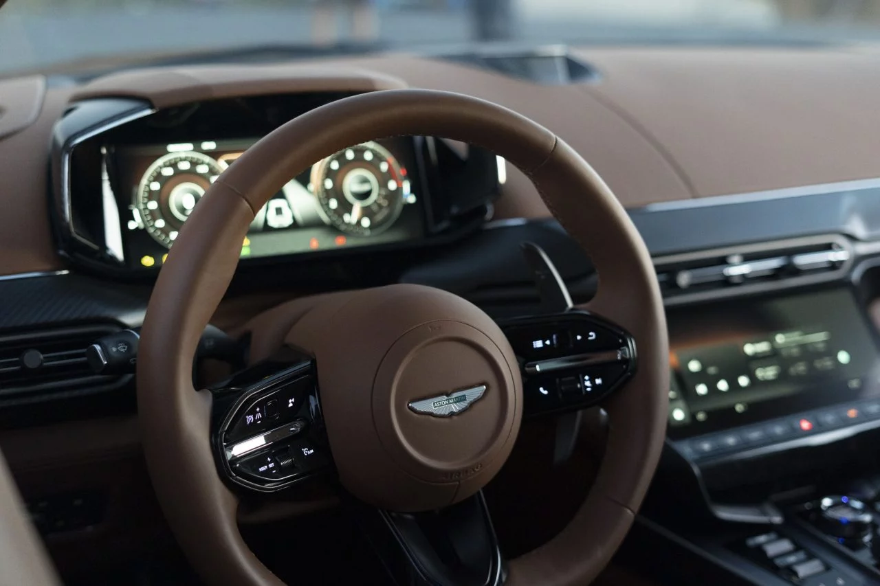 Interior Aston Martin Vanquish muestra elegancia y tecnología con su instrumentación digital y acabados de lujo.