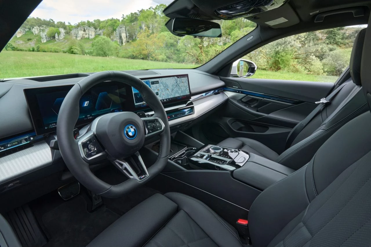 Puesto de conducción BMW Serie 5 Touring con énfasis en el volante y sistema multimedia.