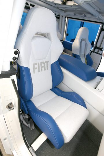 Interior del Fiat 4x4 mostrando asientos con emblema bordado, combinando funcionalidad y diseño.