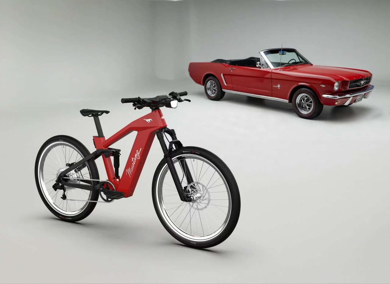 Ford Mustang clásico junto a innovadora e-bike del mismo linaje.