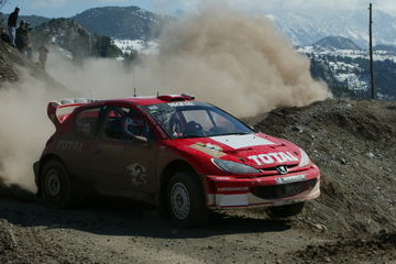 Captura de un coche de rally en acción, demostrando su dinamismo y capacidad en terreno complicado.