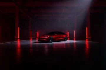 Silueta trasera y lateral del Tesla Model 3 Performance, iluminación tenue.