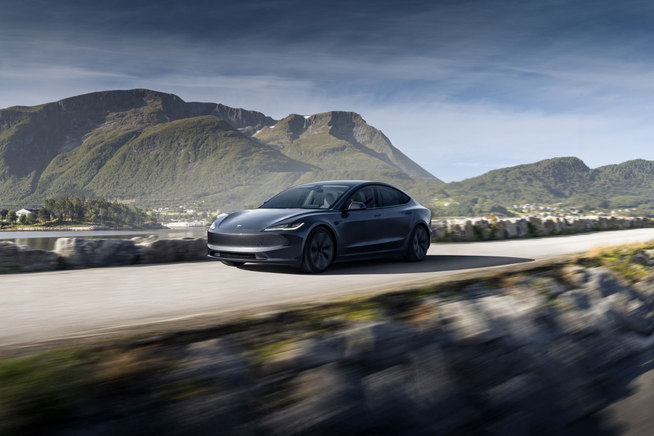 Vista dinámica del Tesla Model 3 en carretera, destacando su diseño aerodinámico