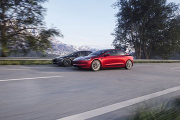 Vista dinámica del Tesla Model 3 en carretera, destacando su diseño lateral moderno.