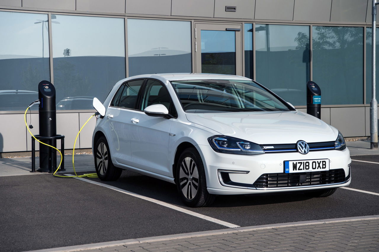 Volkswagen e-Golf en estación de carga, mostrando diseño lateral y eficiencia eléctrica.