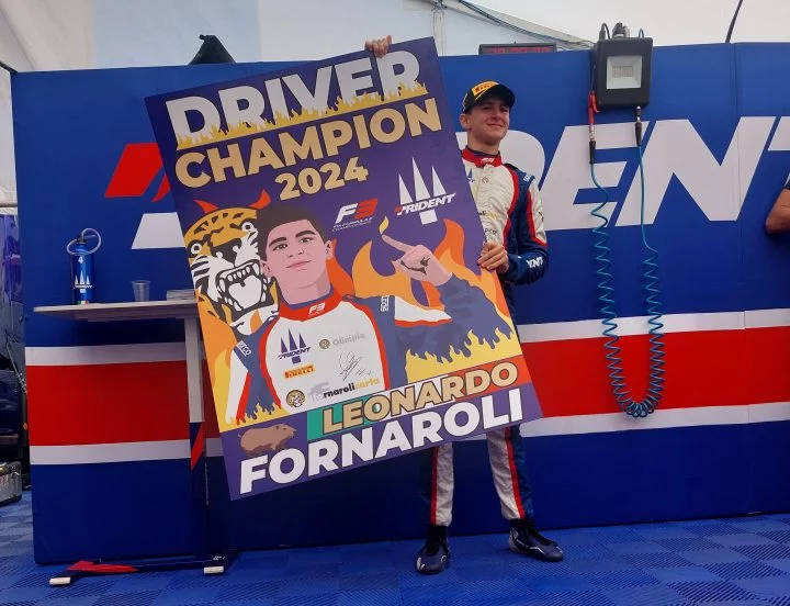 Leonardo Fornaroli posa como campeón junto a su cartel conmemorativo.