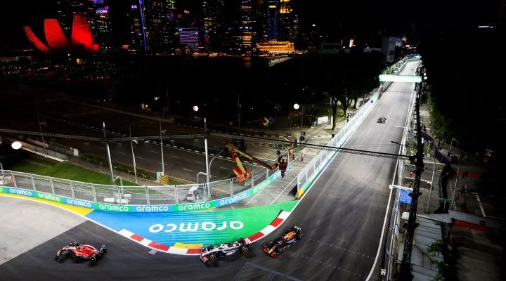 Vista nocturna del circuito de Marina Bay con coche en acción.