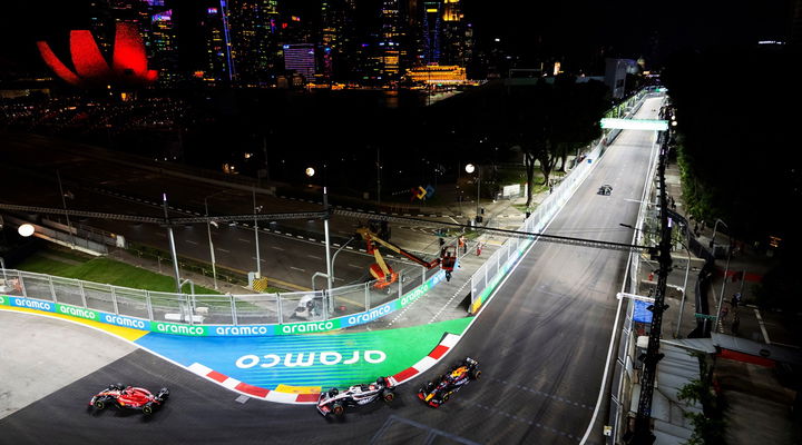 Vista nocturna del circuito de Marina Bay con coche en acción.