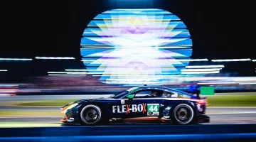 Vista lateral de un Porsche GT3 en acción durante la noche en Daytona