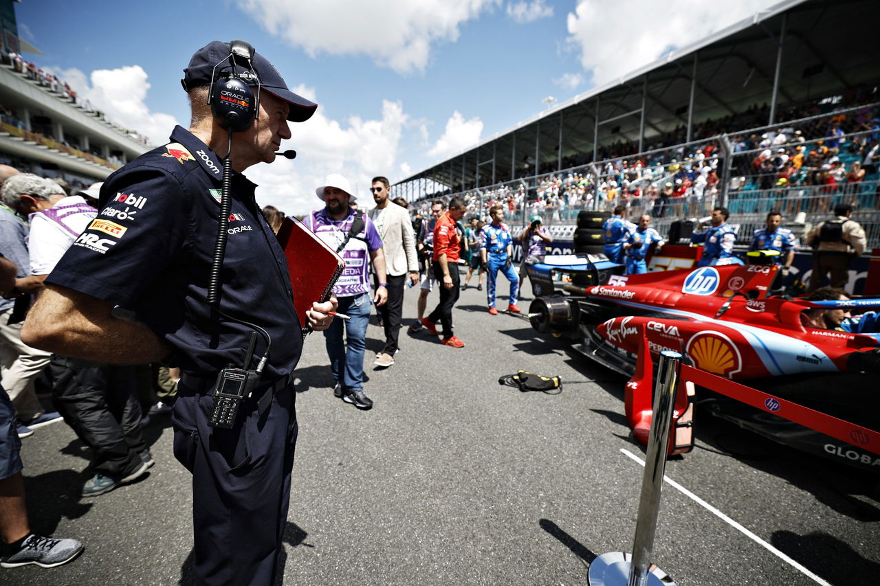 Adrian Newey al lado de un vehículo de Fórmula 1, en un ambiente de competición.